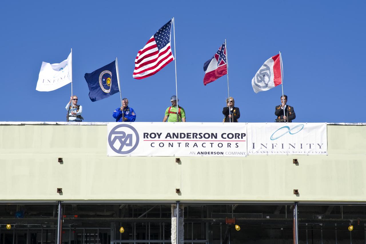 Flags are planted on the roof of the new INFINITY at NASA Stennis Space Center facility under construction just west of the Mississippi Welcome Center at exit 2 on Interstate 10. Stennis and community leaders celebrated the 'topping out' of the new science center Nov. 17, marking a construction milestone for the center. The 72,000-square-foot science and education center will feature space and Earth galleries to showcase the science that underpins the missions of the agencies at Stennis Space Center. The center is targeted to open in 2012.