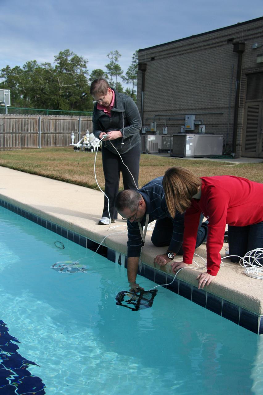David Lalejini, an employee of the Naval Research Laboratory at NASA's John C. Stennis Space Center, helps a pair of teachers deploy a remotely-operated underwater Sea Perch robot during workshop activities Dec. 11. The Stennis Education Office teamed with Naval Research Laboratory counterparts to conduct a two-day workshop Dec. 10-11 for Louisiana and Mississippi teachers. During the no-cost workshop, teachers learned to build and operate Sea Perch robots. The teachers now can take the Sea Perch Program back to students.