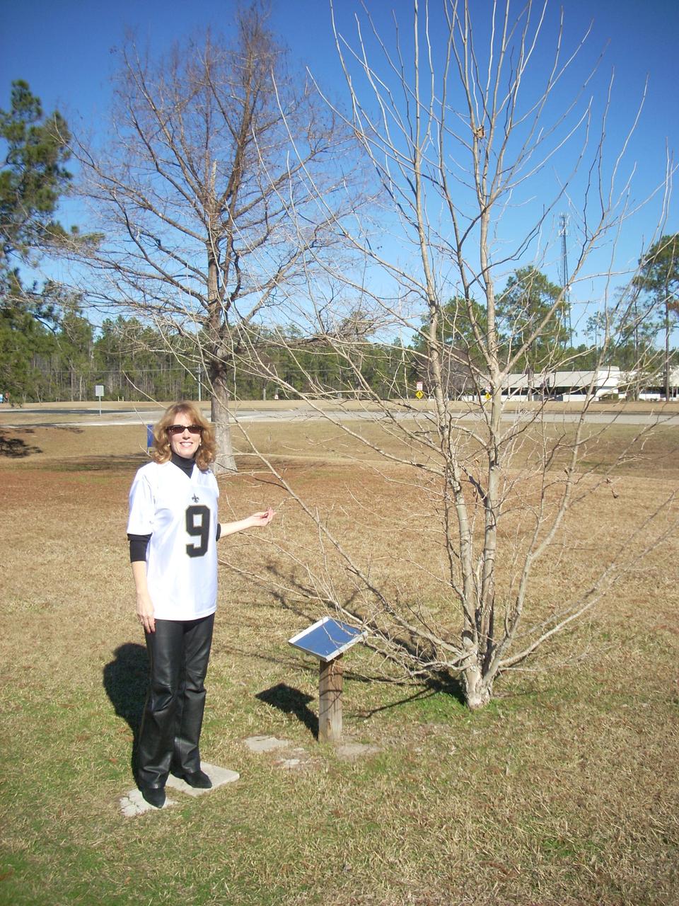 : An image from Jan. 7, 2011, shows Rosemary Roosa, daughter of the late Apollo 14 astronaut Stuart Roosa, standing beside the Moon tree outside of StenniSphere, the previous museum and visitor center at NASA’s Stennis Space Center. The Moon tree is grown from seeds carried to the Moon and back by astronaut Stuart Roosa on the Apollo 14 mission.