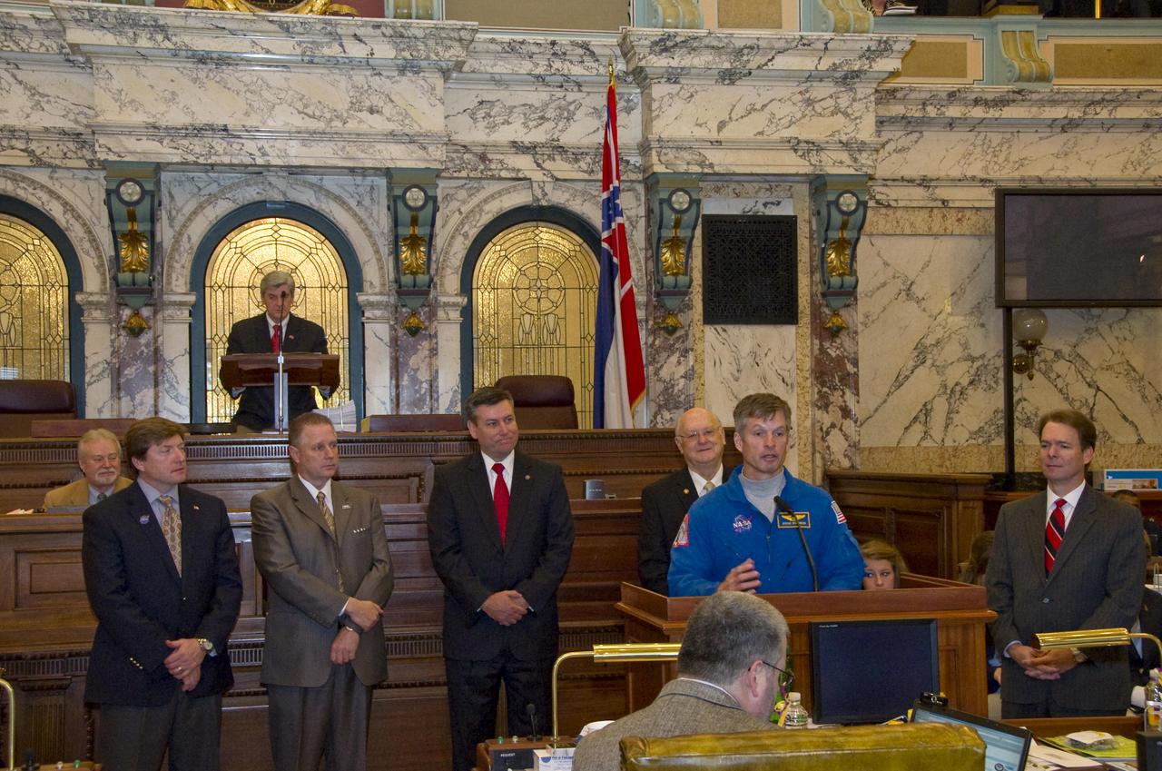 Astronaut Steven Swanson (front) speaks to members of the Mississippi Senate in chambers, with Lt. Gov. Phil Bryant presiding (rear), during NASA Day at the Capitol in Jackson on Feb. 10. Swanson was joined at the podium by Sen. David Baria, D-Bay St. Louis (l to r), NASA Shared Services Center Executive Director Rick Arbuthnot, Stennis Director Patrick Scheuermann, Sen. Ezell Lee, D-Picayune, and Sen. Billy Hewes, R-Gulfport. Baria, Lee and Hewes all are members of the Mississippi Senate Gulf Coast delegation.