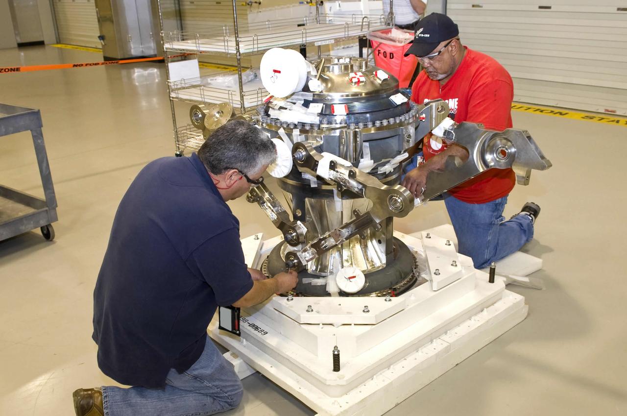 Pratt & Whitney Rocketdyne employees Carlos Alfaro (l) and Oliver Swanier work on the main combustion element of the J-2X rocket engine at their John C. Stennis Space Center facility. Assembly of the J-2X rocket engine to be tested at the site is under way, with completion and delivery to the A-2 Test Stand set for June. The J-2X is being developed as a next-generation engine that can carry humans into deep space. Stennis Space Center is preparing a trio of stands to test the new engine.