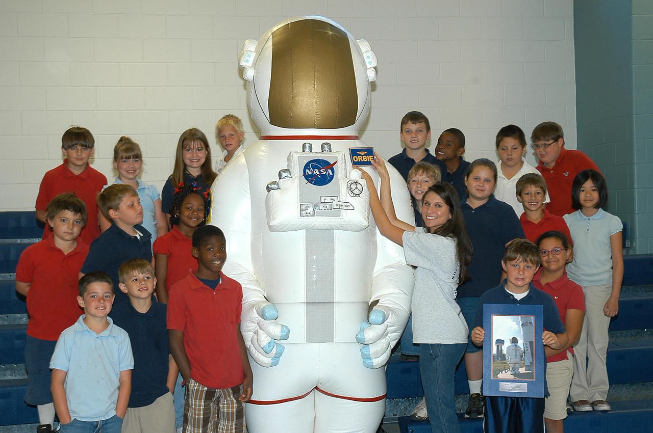 Students at South Hancock Elementary School in Bay St. Louis, Miss., gather around Orbie the Astronaut on May 19 as teacher Sarah Ladner affixes a nameplate to the Stennis Space Center mascot. Members of the third-grade class won a contest to name the inflatable astronaut. Some 20 schools in Louisiana and Mississippi participated in the contest.