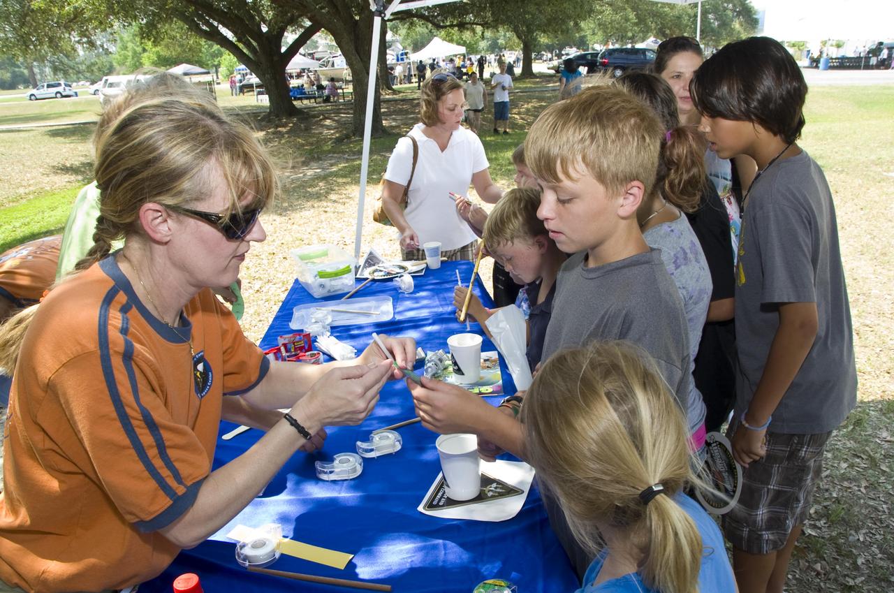 Stennis Space Center Education Office Director Katie Wallace (left) assists a young visitor at an activity table during the 50th Anniversary Open House sponsored by Stennis Space Center on June 2. Stennis hosted the open house as part of its yearlong 50th anniversary celebration.