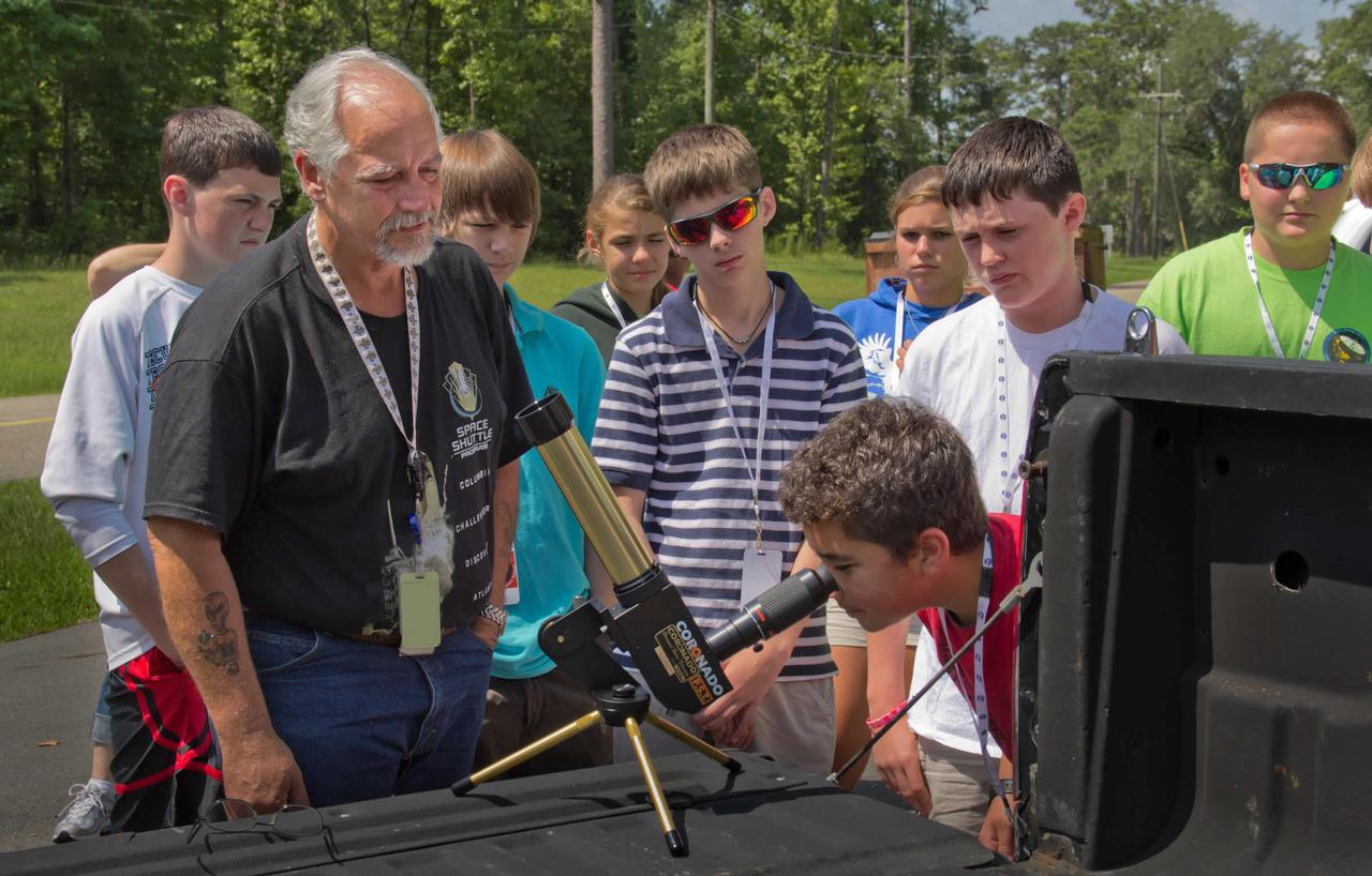 Tom Nicolaides, an aerospace technologist in the Engineering & Test Directorate at Stennis Space Center, looks on as 2011 Astro STARS participants take turns gazing at the sun through a special telescope. The sun-gazing activity was part of the Astro STARS (Spaceflight, Technology, Astronomy & Robotics at Stennis) camp for 13-to-15-year-olds June 27 - July 1. The weeklong science and technology camp is held each year onsite at the rocket engine test facility.