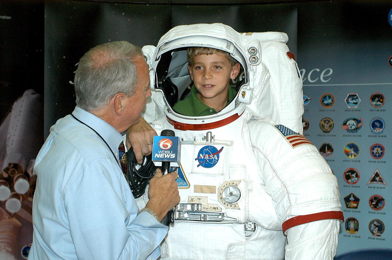 'Astronaut' Patrick Johnston, 8, is interviewed by Heath Allen, a reporter with WDSU-TV in New Orleans, about his experience at the INFINITY at NASA Stennis Space Center facility during ribbon-cutting activities April 11, 2012.