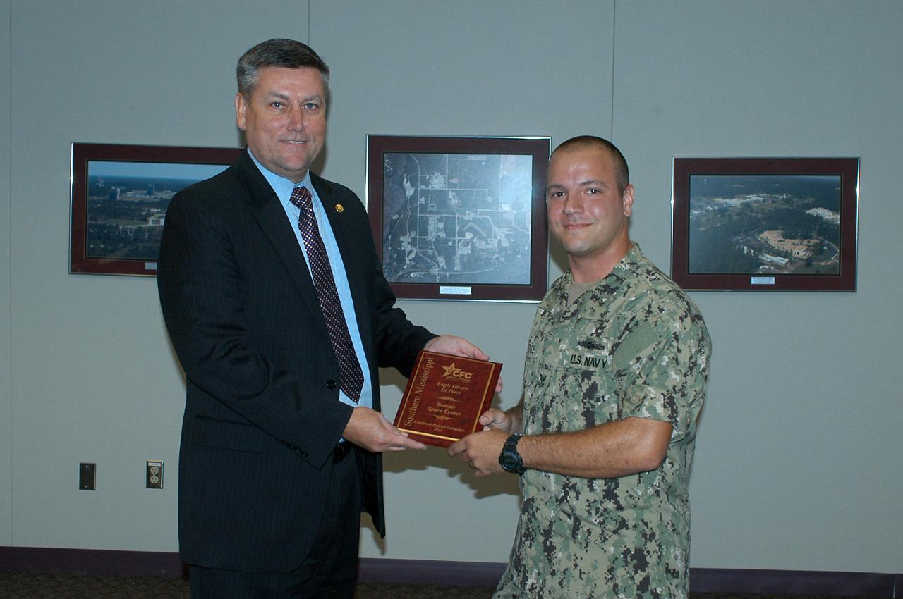U.S. Navy HT 2 Ryan Vinnedge (right) presents a Combined Federal Campaign award to Stennis Space Center Director Patrick Scheuermann during a May 16, 2012, ceremony. Stennis employees led the way in two categories in the 2011 Southern Mississippi CFC effort, ranking first in the number of Eagle Givers (more than $480 each) and in dollar increase of contributions. Stennis Space Center employees contributed $221,000 through the campaign.