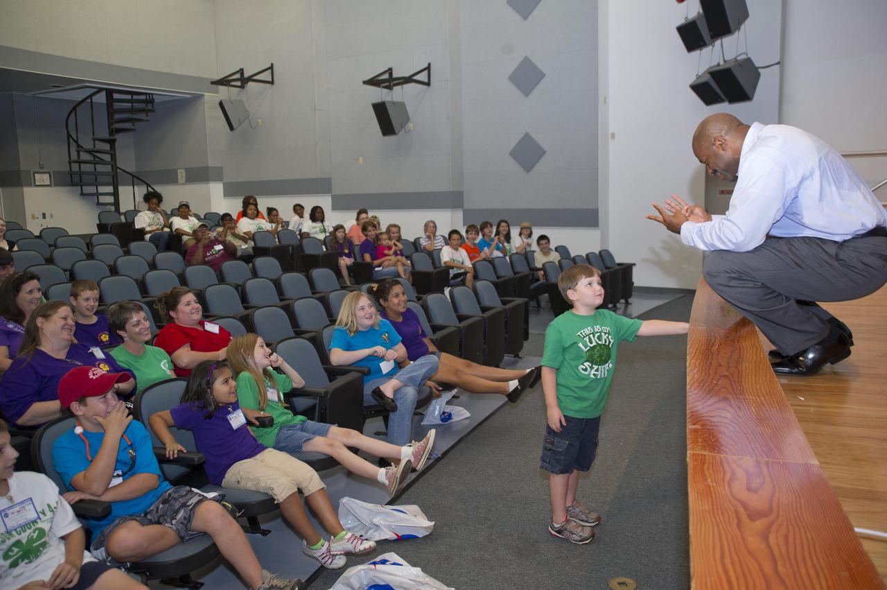 NASA Associate Administrator for Education Leland Melvin speaks with 7-year-old Ben at the beginning of a presentation to Mississippi 4-H students at John C. Stennis Space Center on July 30, 2012. Melvin predicted Ben could be a future astronaut, urging students to discover and prepare to make their dreams into reality as well.