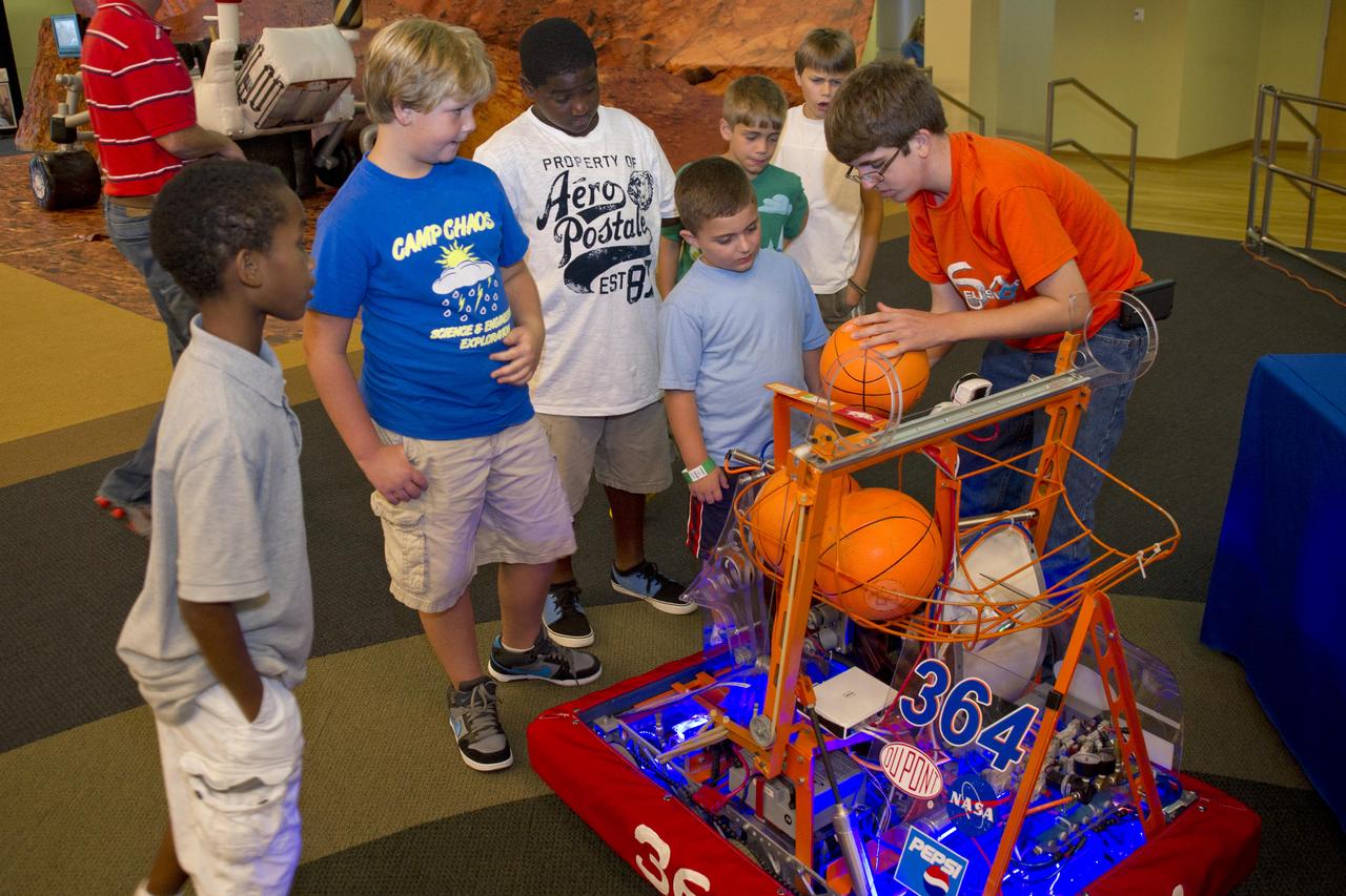 NASA welcomed hundreds of children and accompanying adults to its INFINITY visitor center on Aug. 4, offering Mars-related activities that focused attention on the space agency's Curiosity mission to the Red Planet. Among other things, students from Gulfport High School, who field a team each year in the FIRST (For Inspiration and Recognition of Science and Technology) Robotics Competition, offered young visitors a firsthand look at how robots work Hundreds of persons visited the INFINITY facility during the day, including media representatives from surrounding communities.