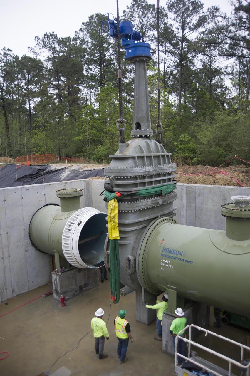 Stennis Space Center employees install a 96-inch valve during a recent upgrade of the high-pressure industrial water system that serves the site’s large rocket engine test stands. The upgraded system has a capacity to flow 335,000 gallons of water a minute, which is a critical element for testing. At Stennis, engines are anchored in place on large test stands and fired just as they are during an actual space flight. The fire and exhaust from the test is redirected out of the stand by a large flame trench. A water deluge system directs thousands of gallons of water needed to cool the exhaust. Water also must be available for fire suppression in the event of a mishap. The new system supports RS-25 engine testing on the A-1 Test Stand, as well as testing of the core stage of NASA’s new Space Launch System on the B-2 Test Stand at Stennis.