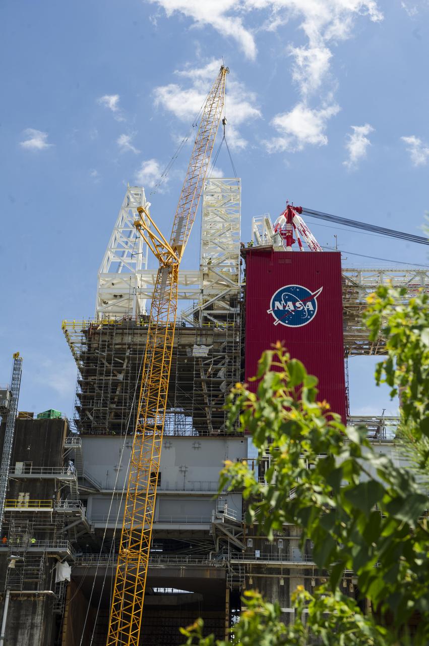 A structural steel section is lifted into place atop the B-2 Test Stand at NASA’s Stennis Space Center as part of modification work to prepare for testing the core stage of NASA’s new Space Launch System. The section is part of the Main Propulsion Test Article (MPTA) framework, which will support the SLS core stage for testing. The existing framework was installed on the stand in the late 1970s to test the shuttle MPTA. However, that framework had to be repositioned and modified to accommodate the larger SLS stage. About 1 million pounds of structural steel has been added, extending the framework about 100 feet higher and providing a new look to the Stennis skyline. Stennis will test the actual flight core stage for the first uncrewed SLS mission, Exploration Mission-1.