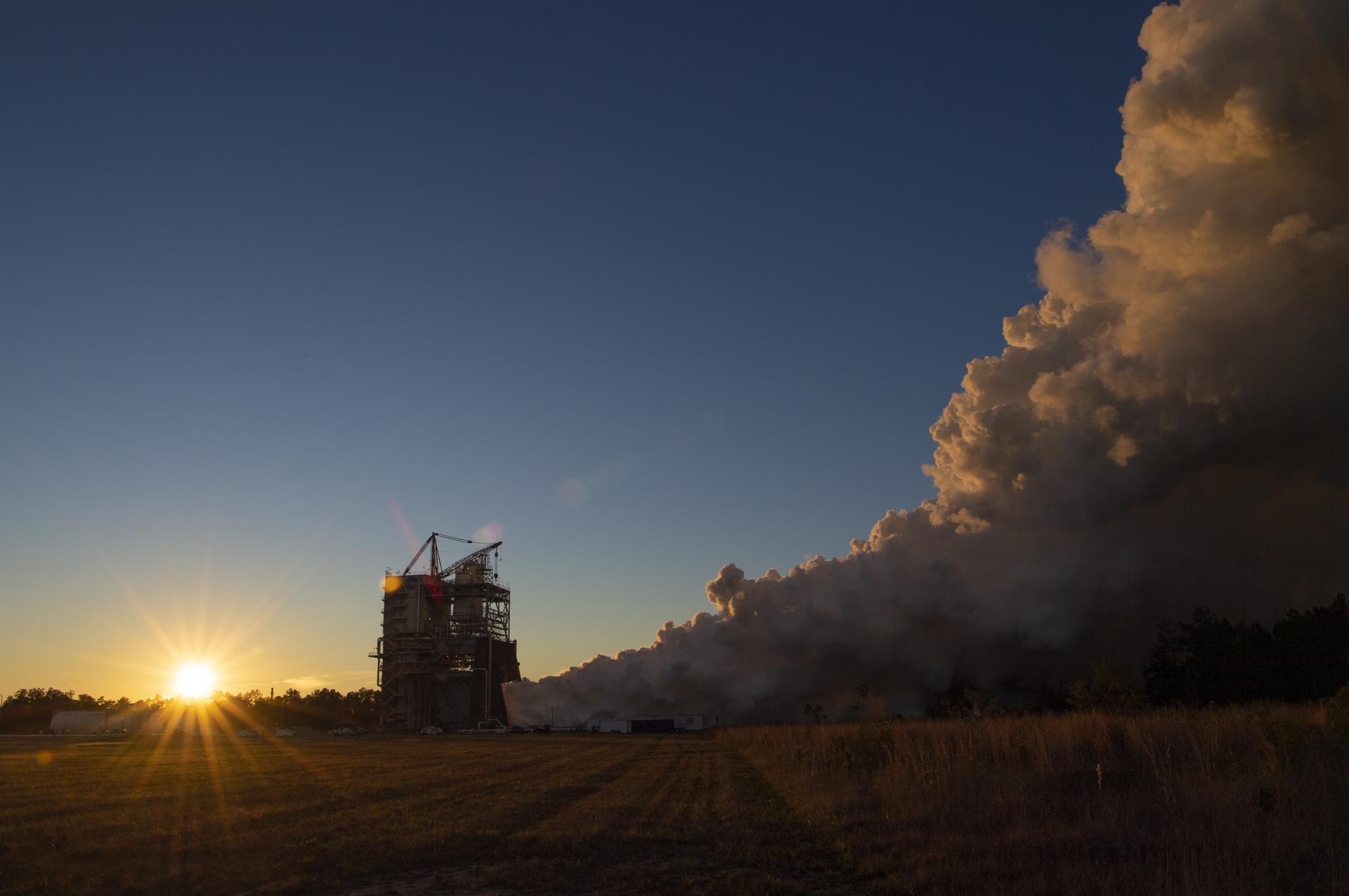 vapor clouds rise high as the sun sets during an engine test