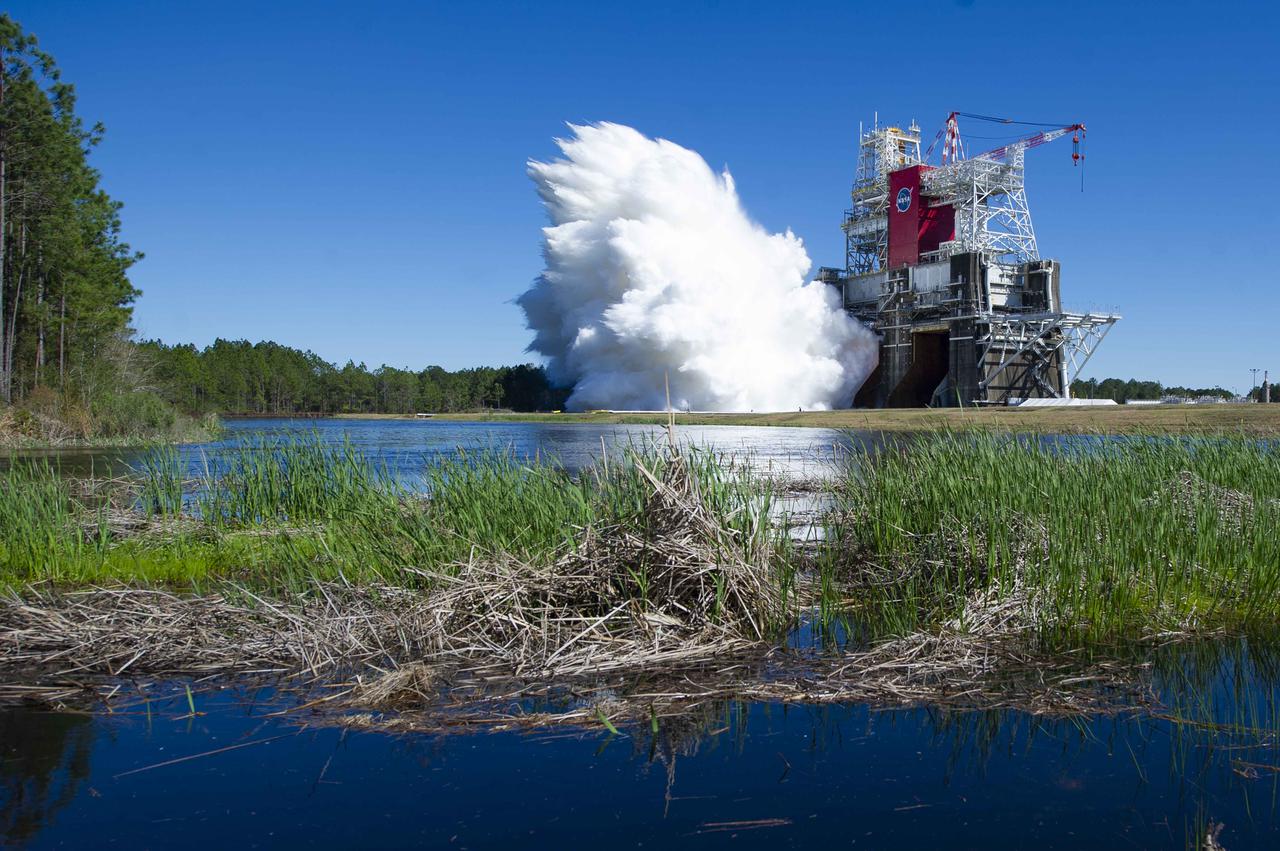 NASA conducts a hot fire test March 18, 2021, of the core stage for the agency’s Space Launch System rocket on the B-2 Test Stand at Stennis Space Center near Bay St. Louis, Mississippi. The hot fire test of the stage’s four RS-25 engines generated a combined 1.6 million pounds of thrust, just as will occur during an actual launch. The hot fire is the final test of the Green Run test series, which represents a comprehensive assessment of the core stage and its integrated systems prior to its launch on the Artemis I mission to the Moon.