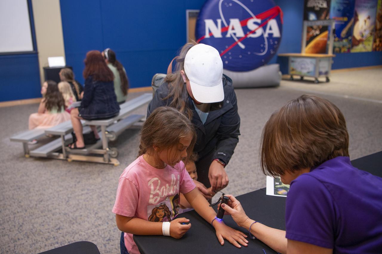 NASA Visitor Relations Specialist Holley Argus conducts an activity with visitors at INFINITY Science Center, the official visitor center of NASA’s Stennis Space Center, on April 8.