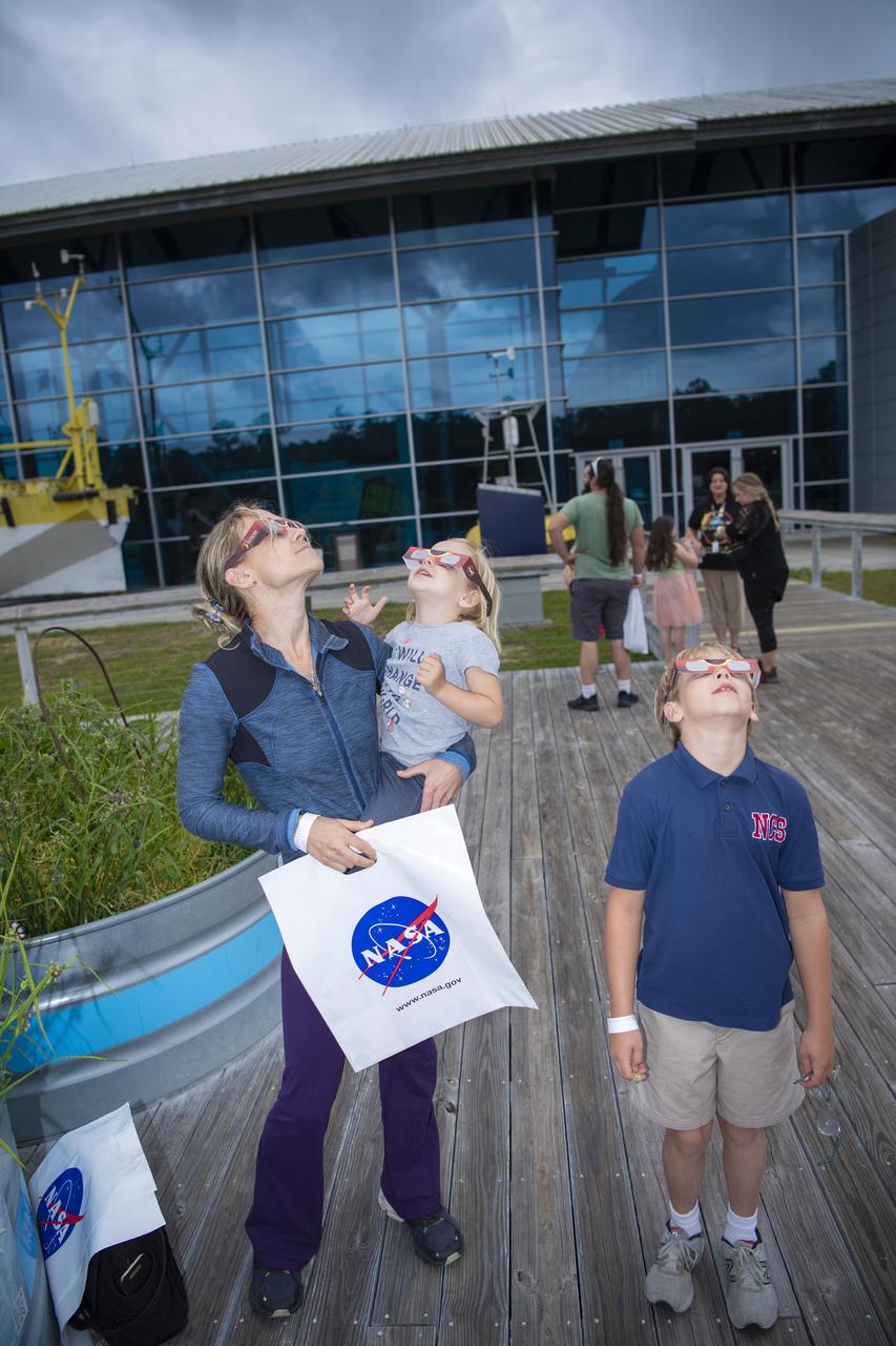 A family looks to the skies for the eclipse outside of INFINITY Science Center, the official visitor center of NASA’s Stennis Space Center, on April 8.