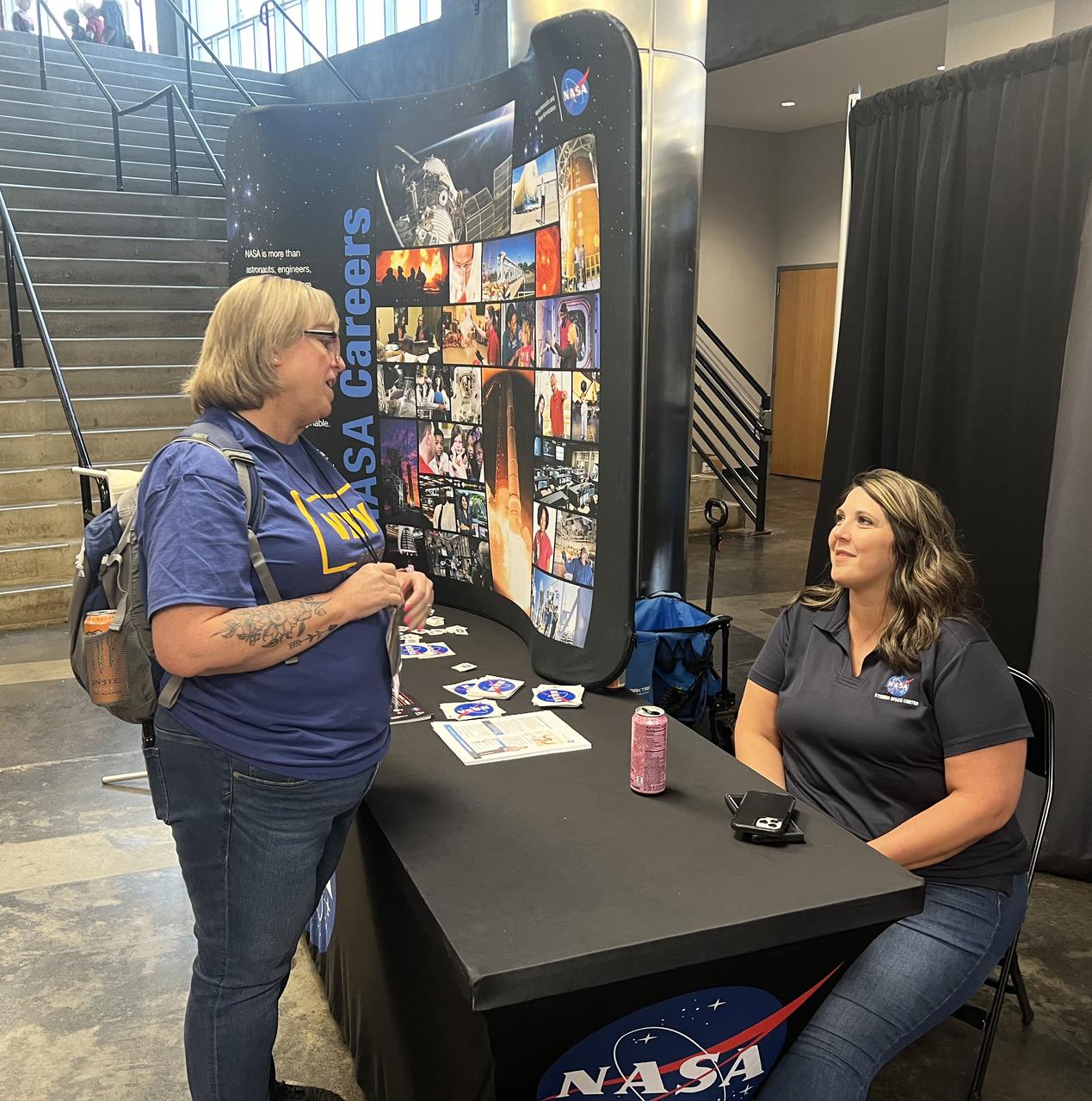 A Mississippi Comic Convention worker, an advocate for children with disabilities, speaks with NASA Stennis budget analyst Rebecca Mataya, right, during the event in Jackson, Mississippi, on June 22, about community outreach events and INFINITY Science Center’s ability to host children with special needs interested in learning more about NASA.