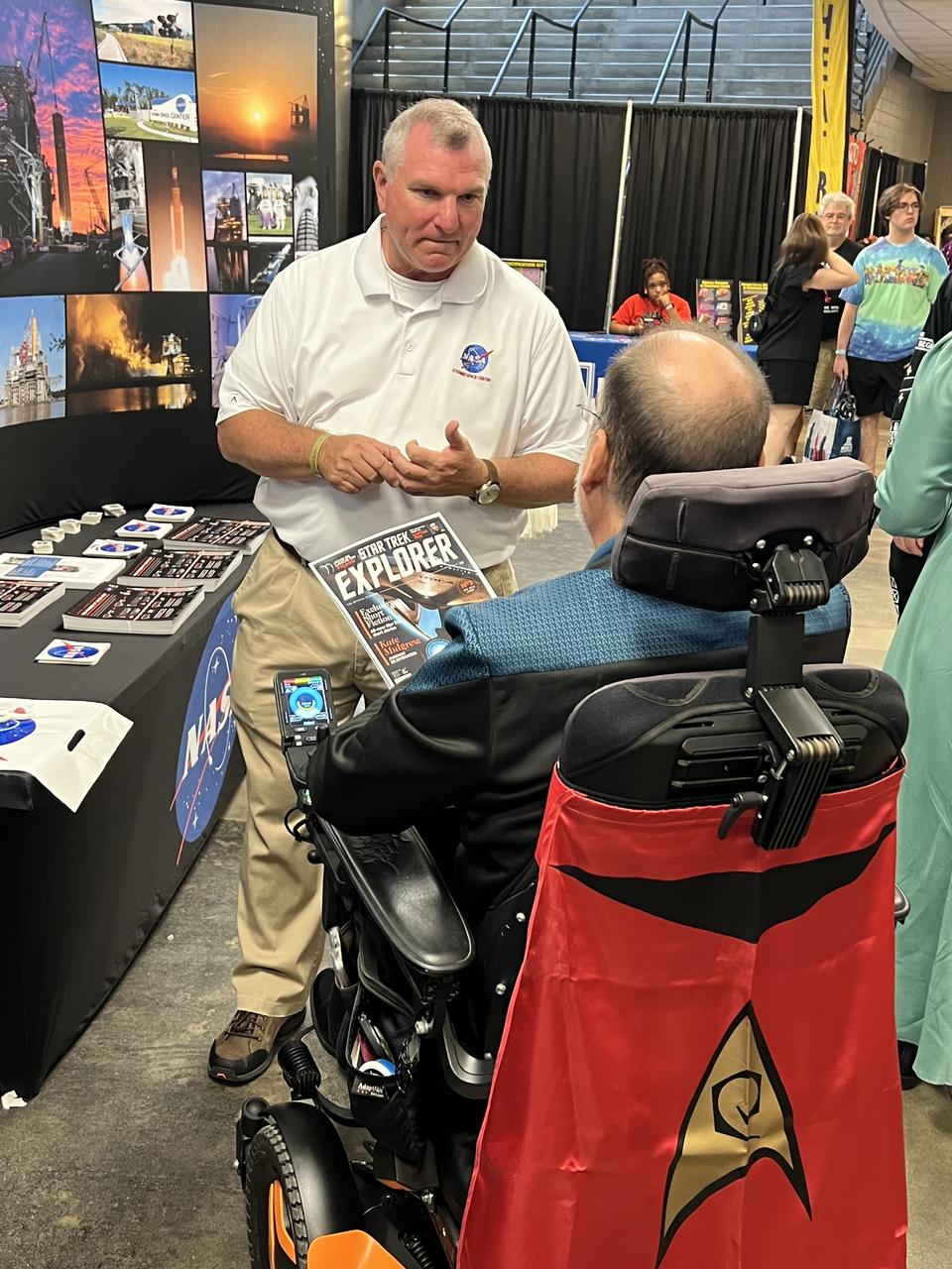 NASA Stennis legislative affairs specialist and chief of staff Troy Frisbie discusses his appearance in Star Trek Explorer magazine with a member of the Jackson, Mississippi, Star Trek fan club, USS Haise.