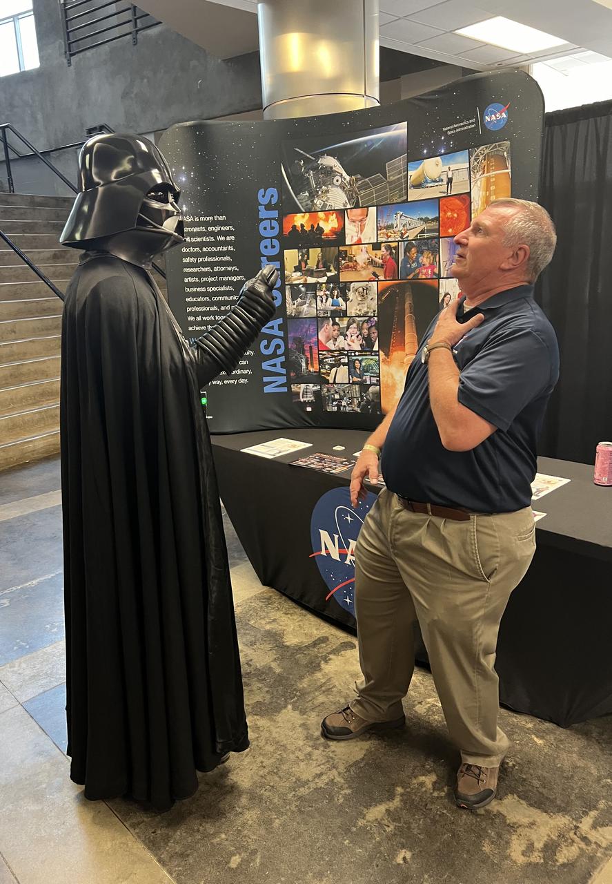 A Darth Vader character visits with NASA Stennis legislative affairs specialist and chief of staff Troy Frisbie at the NASA booth on June 23 at the Mississippi Comic Convention in Jackson, Mississippi.