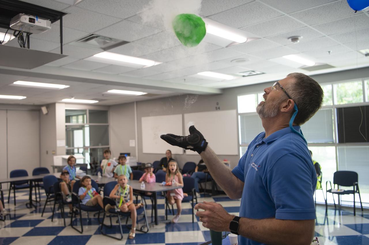 A group of Take Our Children Day participants watch a cryogenic demonstration led by Allen Forsman of Aerojet Rocketdyne, an L3Harris Technologies company, on June 27 at the Aerojet Rocketdyne Engine Assembly Facility at NASA Stennis.