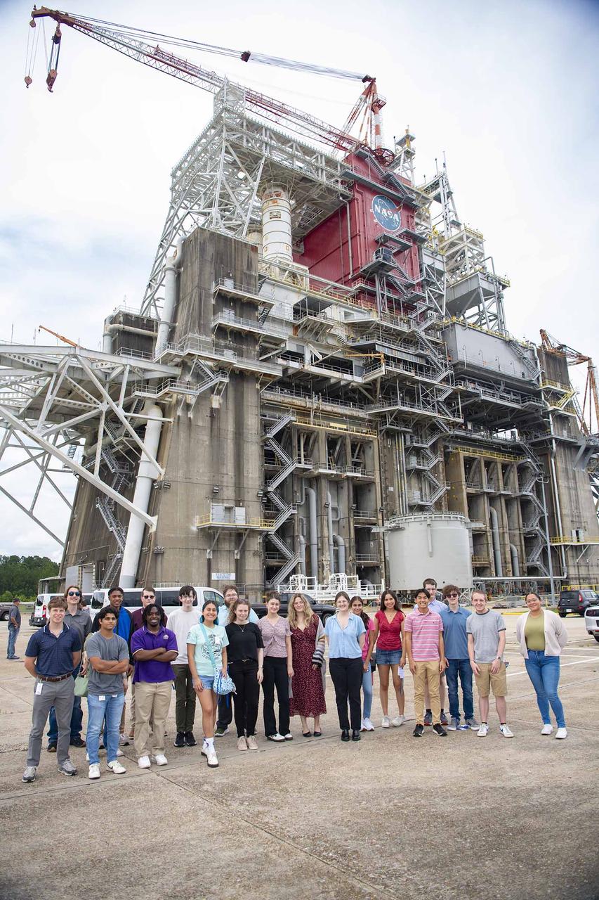 Summer interns with the U.S. Naval Research Laboratory stand in front of the Thad Cochran Test Stand (B-1/B-2) on July 10. NASA Stennis crews are preparing the B-2 side of the stand for future testing of NASA’s exploration upper stage. The more powerful second stage is expected to fly on NASA’s SLS (Space Launch System) rocket for Artemis IV. The Naval Research Laboratory interns visited the stand during an afternoon tour of NASA Stennis. The Naval Research Laboratory is a tenant of the NASA Stennis federal city, where it provides advanced scientific capabilities required to bolster the nation’s position of global naval leadership.