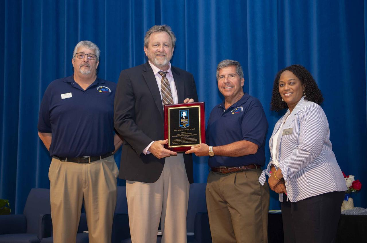 The Navy Exchange Service Command presented NEX Stennis with the 2023 Bingham Award during an Aug. 26 ceremony at NASA’s Stennis Space Center near Bay St. Louis, Mississippi. NEX Stennis, a gas station and minimart at NASA Stennis, is one of nine winners for the award recognizing excellence in customer service, operations, and management. NEX Stennis and the Naval Construction Battalion in Gulfport, Mississippi, topped sales category six by earning between $2.5 million and $4 million for the year. NASA Stennis Associate Director Rodney McKellip accepted the award on behalf of the center. Pictured (left to right) are Steve Dienes, NEX Stennis manager; McKellip; Robert Bianchi, rear admiral (retired) and chief executive officer of the Navy Exchange Service Command; and Katie Wilson, NEX Stennis general manager.
