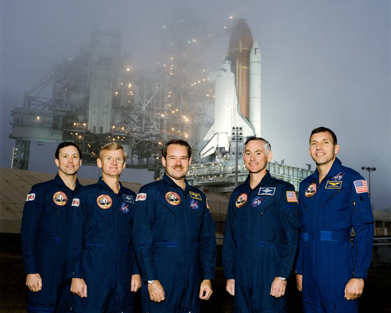 STS036-S-002 (21 Nov. 1989) --- The five astronauts in training for STS-36 pose near the Space Shuttle Discovery on Launch Pad 39B. Astronaut John O. Creighton (center) is mission commander. Others pictured are (left to right) astronauts Pierre J. Thuot, John H. Casper, Richard M. (Mike) Mullane and David C. Hilmers. Casper is pilot and the other three are mission specialists for the DOD-devoted mission.