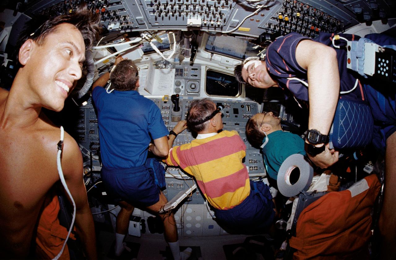 STS046-14-013 (4 Aug. 1992) --- Five of the seven crew members squeezed into this busy scene on the Space Shuttle Atlantis' flight deck during operations with the Tethered Satellite System (TSS). Pictured are, left to right, Franklin R. Chang-Diaz, Loren J. Shriver, Claude Nicollier, Franco Malerba and Andrew M. Allen. Not pictured are astronauts Jeffrey A. Hoffman and Marsha S. Ivins. Mission specialist Ivins used a 35mm camera with a 16mm lens to take this picture.