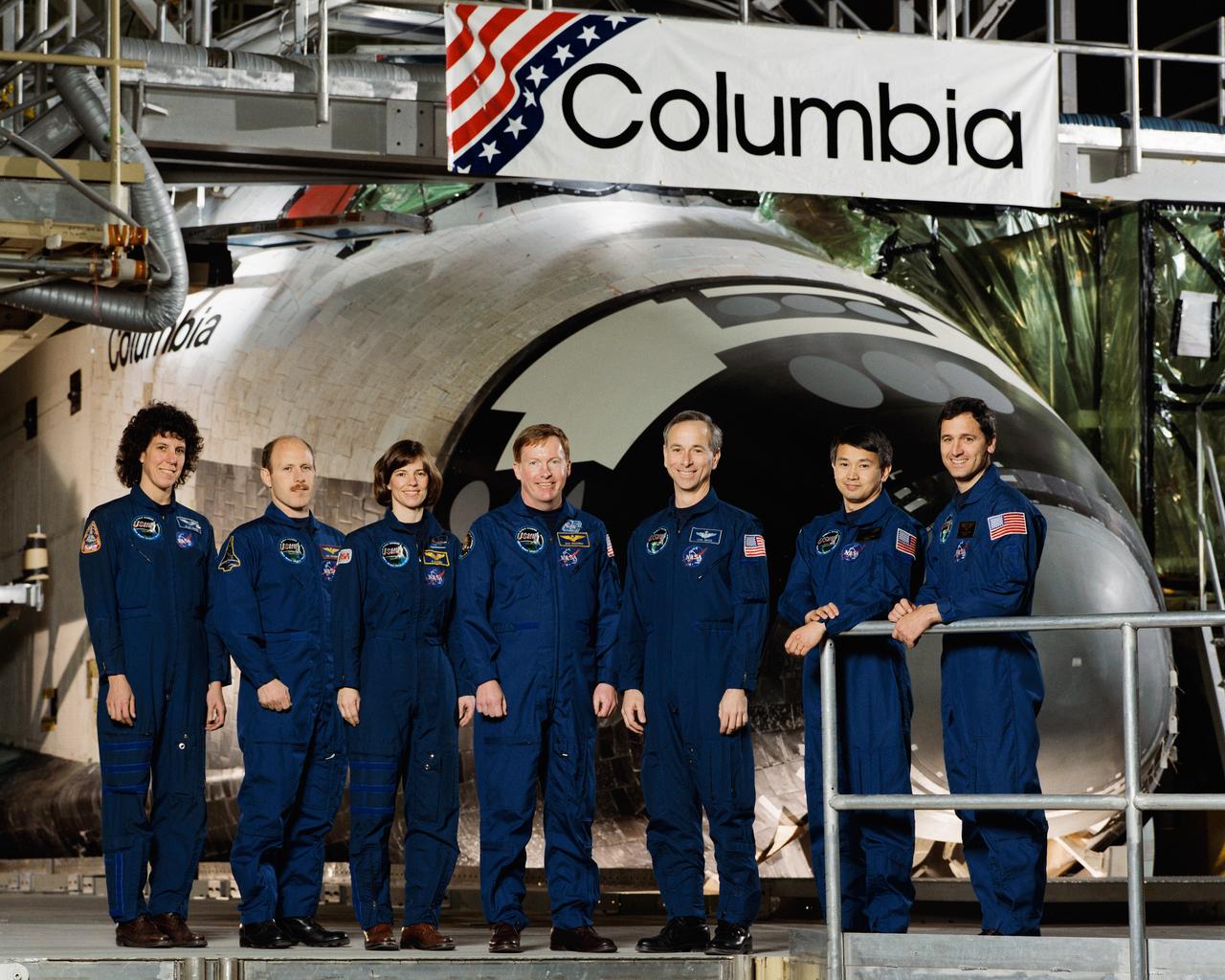 STS050-S-002 (24 Jan. 1992) --- The seven crew members assigned to NASA's mission pose for the traditional crew portrait.  The crew was in Palmdale, California for the Space Shuttle Columbia's Extended-Duration Orbiter (EDO) modifications roll-out.  Astronaut Richard N. Richards, mission commander, is center.  Astronaut Kenneth D. Bowersox, pilot, is second from left.  Others, left to right, are astronauts Ellen S. Baker, mission specialist; Bonnie J. Dunbar, payload commander; and Carl J. Meade, mission specialist; Eugene H. Trinh and Lawrence J. DeLucas, payload specialists.