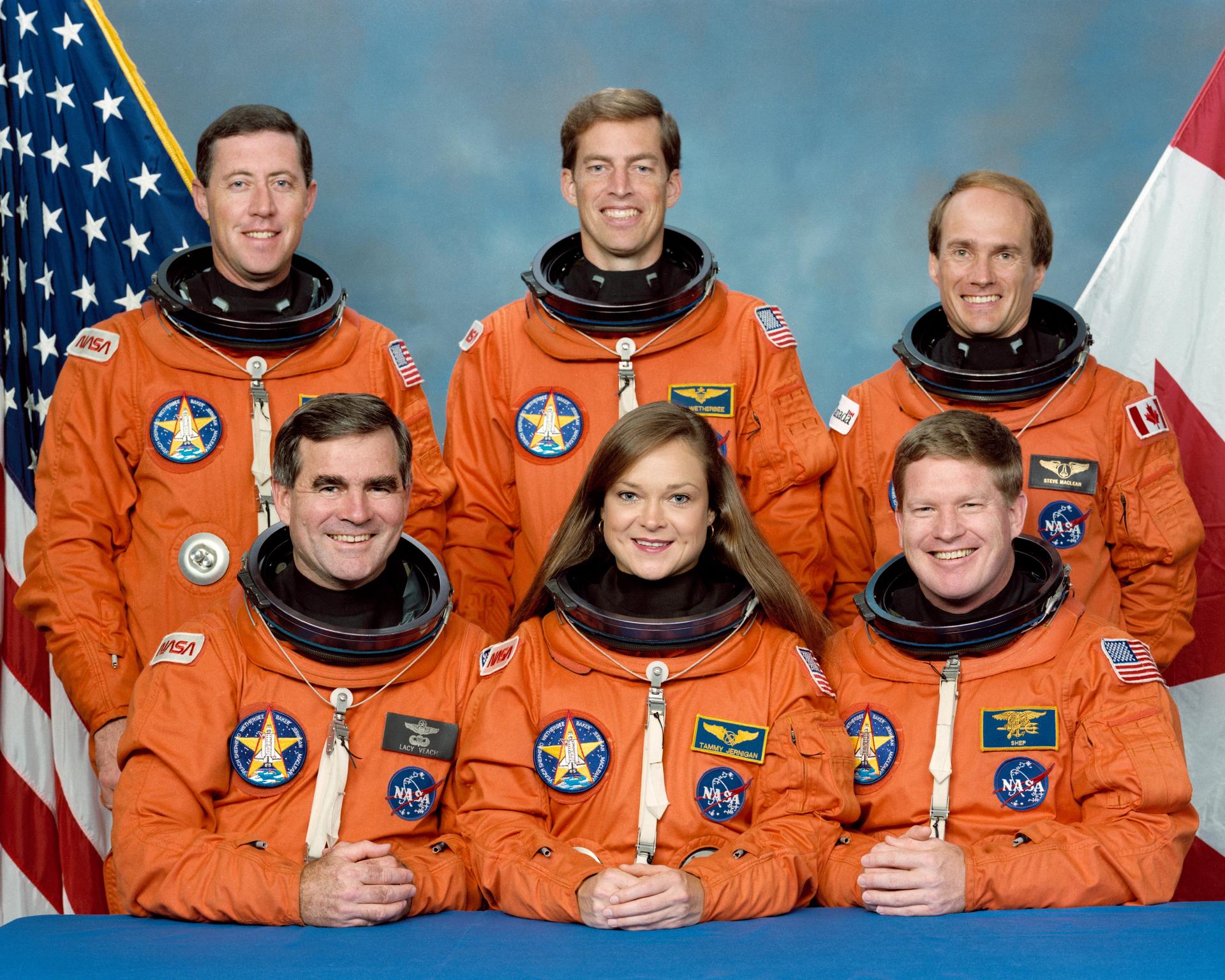 STS-52 Crew Portrait with American and Canadian flags behind them