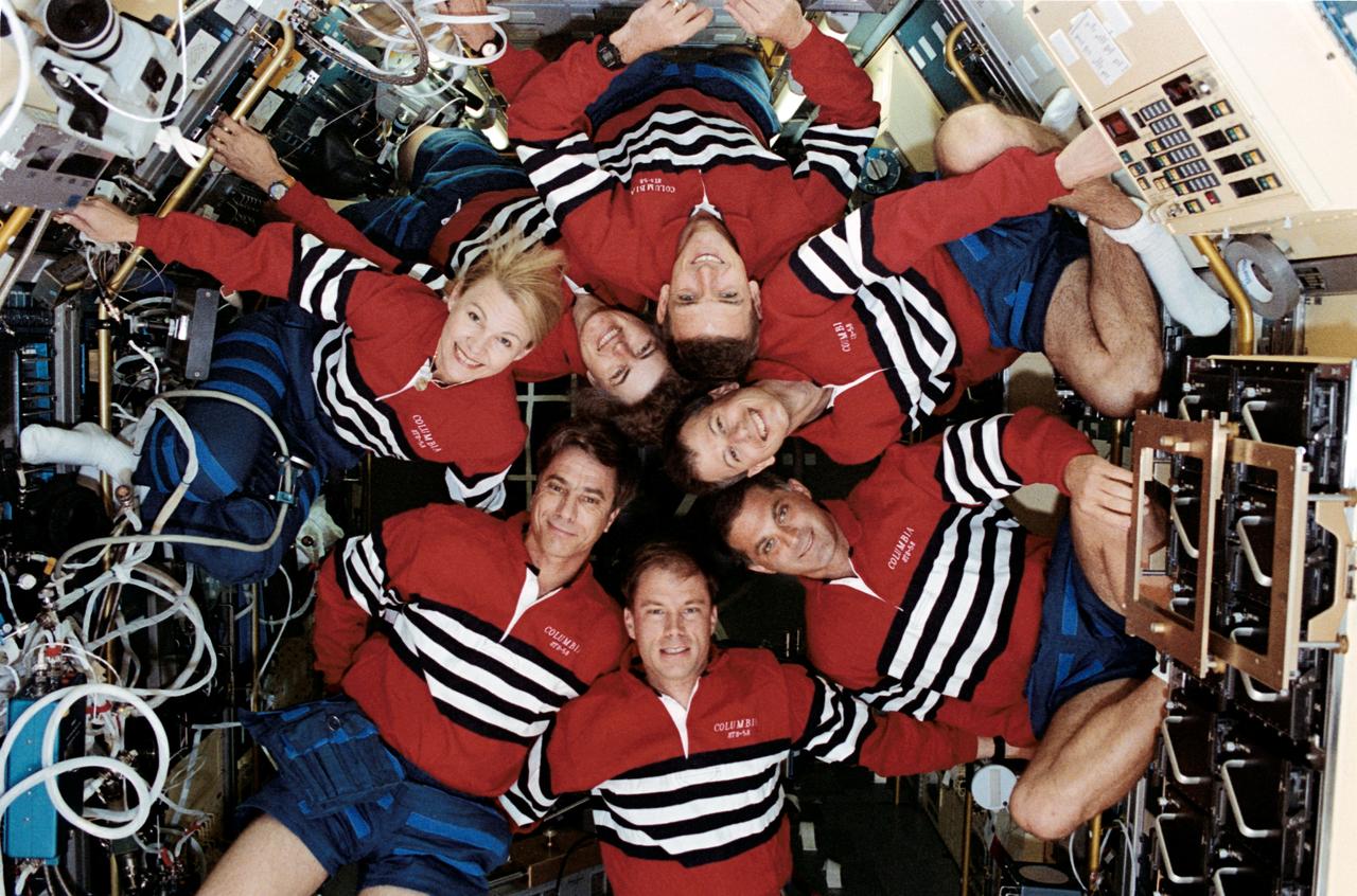 STS058-16-008 (18 Oct.-1 Nov. 1993) --- Inside the science module aboard the Earth-orbiting space shuttle Columbia, a pre-set 35mm camera recorded the traditional inflight portrait of the STS-58 crew. Pictured are (counter-clockwise from the roll of tape at upper right) payload specialist Martin J. Fettman, DVM; William S. McArthur and Shannon W. Lucid, mission specialists; Rhea Seddon, payload commander; John E. Blaha, mission commander; Richard A. Searfoss, pilot; and David A. Wolf, mission specialist. Photo credit: NASA