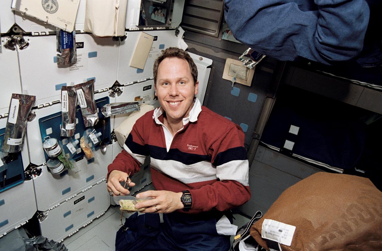 STS059-14-004 (9-20 April 1994) --- On the Space Shuttle Endeavour's middeck astronaut Thomas D. Jones, mission specialist, cuts open a package of food as he prepares for mealtime. Jones was joined by five other NASA astronauts aboard Endeavour for the STS-59 mission.