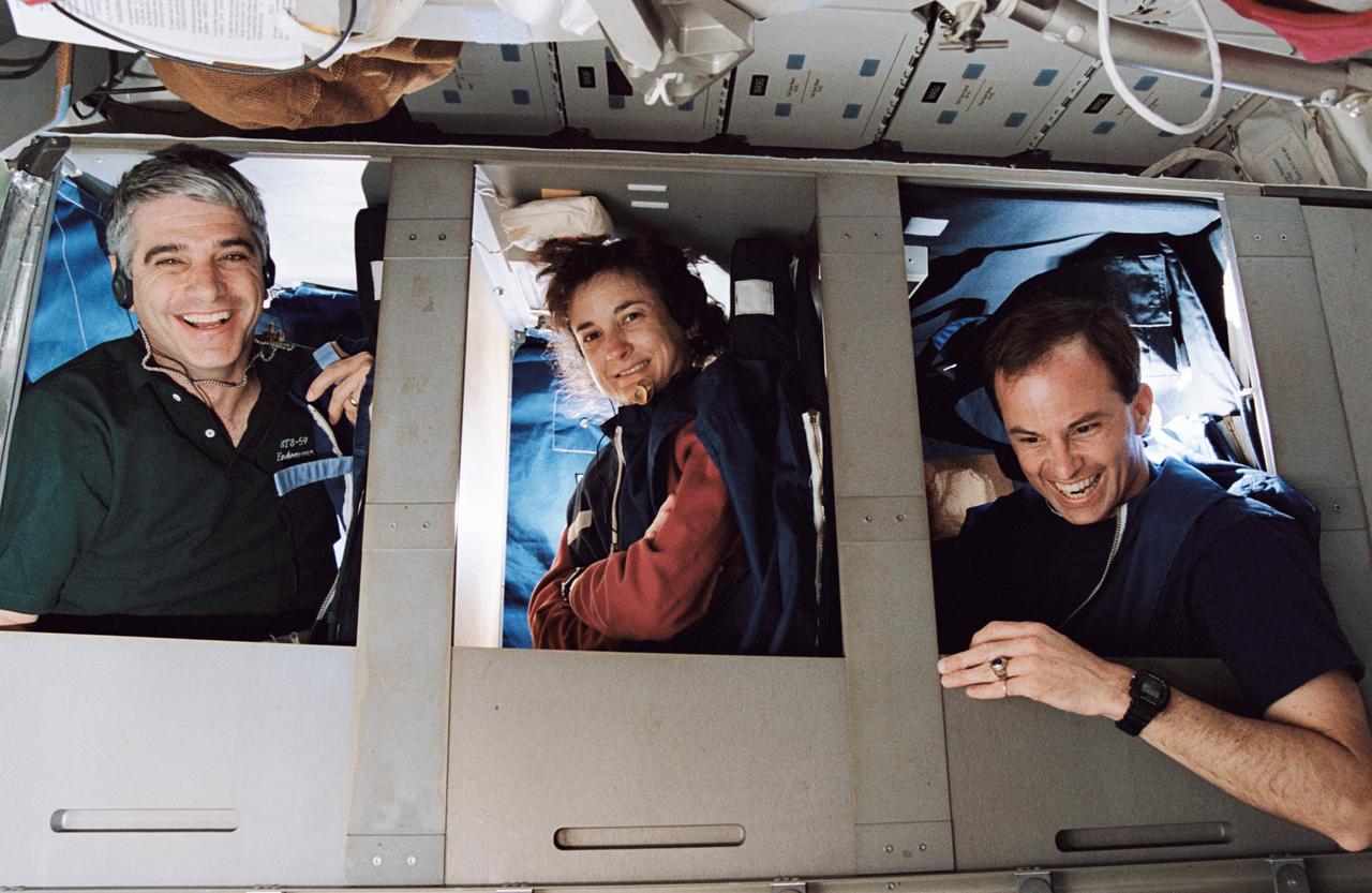 STS059-22-004 (9-20 April 1994) --- Half of Space Shuttle Endeavour's crew of six astronauts are pictured in bunks on the middeck. With the picture held horizontally, the red shift crew members pictured are, left to right, astronauts Sidney M. Gutierrez, mission commander; Linda M. Godwin, payload commander; and Kevin P. Chilton, pilot.