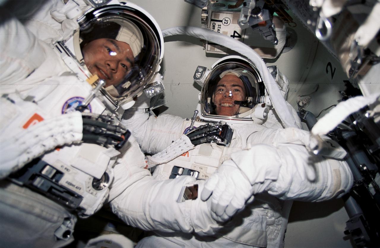 STS072-391-009 (15 Jan. 1996) --- In the Space Shuttle Endeavour's airlock, astronauts Leroy Chiao (left) and Daniel T. Barry prepare for the first extravehicular activity (EVA) scheduled on the mission. The two EVA's were scheduled to evaluate space station assembly techniques.
