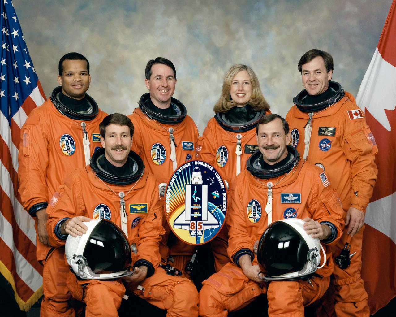 STS085-S-002 (May 1997) --- Five NASA astronauts and a Canadian payload specialist pause from their training schedule to pose for the traditional crew portrait for their mission. In front are astronauts Curtis L. Brown, Jr. (right), mission commander, and Kent V. Rominger, pilot. On the back row, from the left, are astronauts Robert L. Curbeam, Jr., Stephen K. Robinson and N. Jan Davis, all mission specialists, along with the Canadian Space Agency’s (CSA) payload specialist Bjarni Tryggvason.