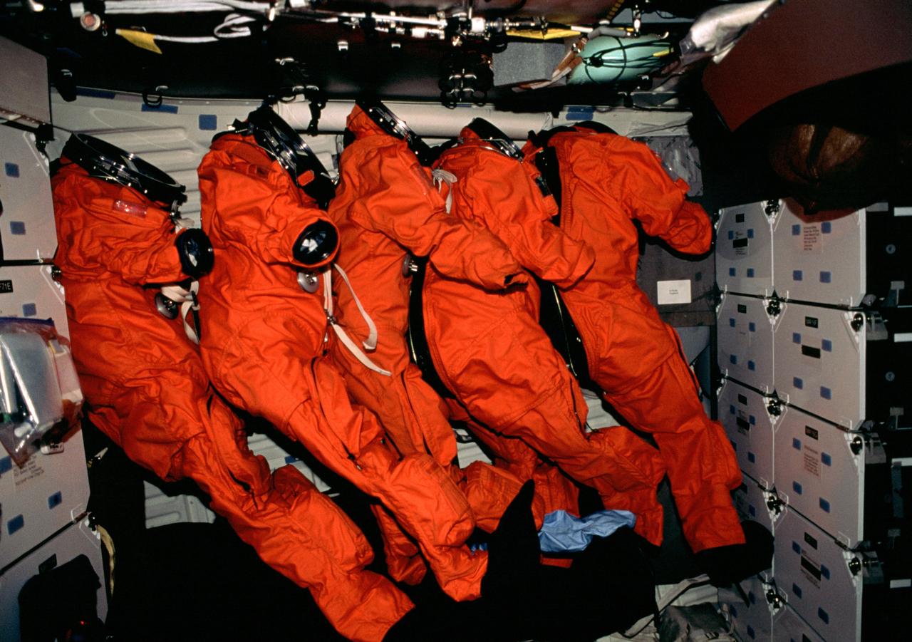 STS098-306-034 (7-20 February 2001) --- The STS-98 crew members&#0146; full-pressure ascent and entry escape suits are lined up on the mid deck of the Earth-orbiting Space Shuttle Atlantis.