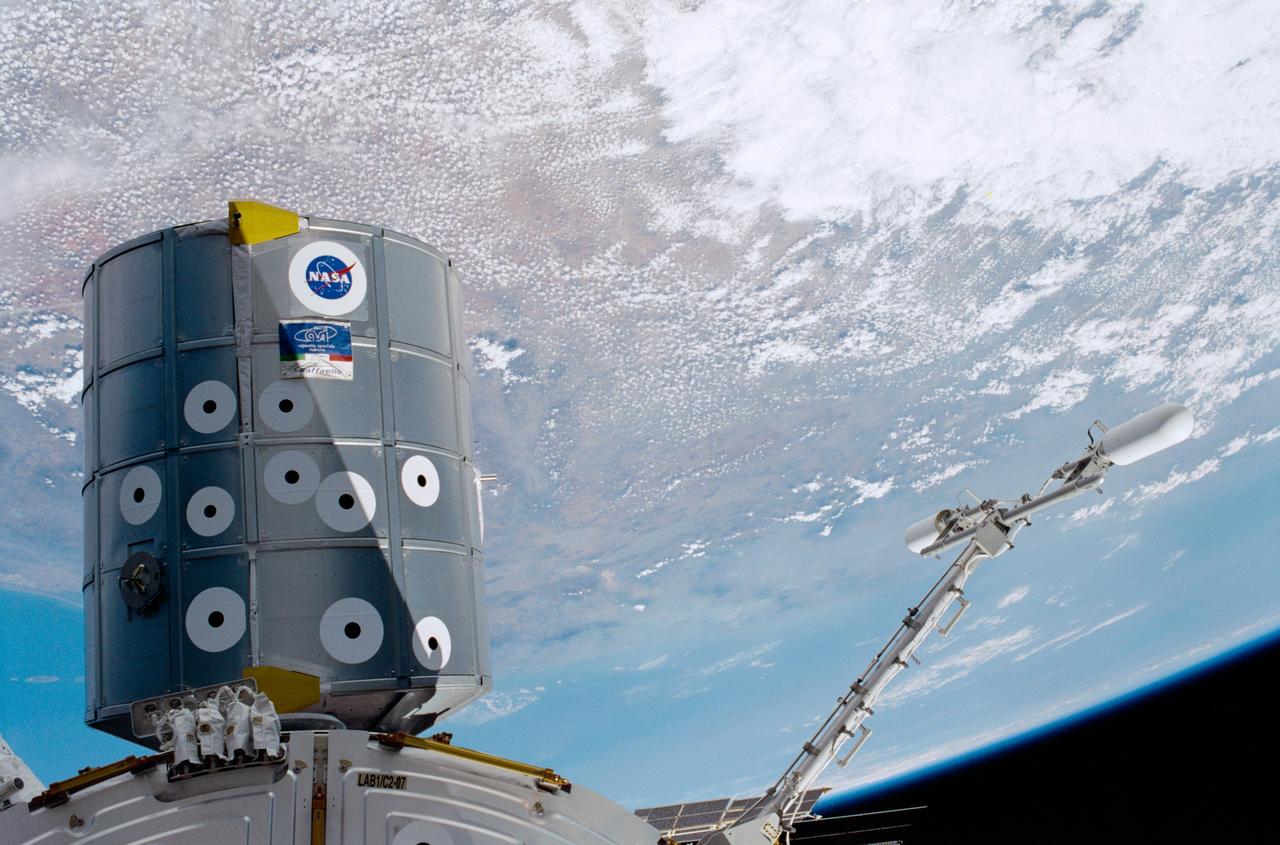 STS100-398-017 (19 April-1 May 2001) --- Backdropped by the Earth with partial cloud cover, the Raffaello Multi-Purpose Logistics Module (MPLM) and the Ultra High Frequency (UHF) antenna are photographed by a crewmember during this STS-100 mission to the International Space Station (ISS). The Raffaello, which was built by the Italian Space Agency (ASI), is the second of three such pressurized modules that will serve as ISS "moving vans", carrying laboratory racks filled with equipment, experiments and supplies to and from the station aboard the space shuttle. The UHF antenna was attached to the station's U.S. Laboratory Destiny by space walking astronauts Chris A. Hadfield and Scott E. Parazynski during the mission's first spacewalk. The antenna, on a 1.2-meter (4-foot) boom, is part of the UHF Communications Subsystem of the station. It will interact with systems already aboard the station, including the Space-to-Space Station Radio transceivers. A second antenna will be delivered on the STS-115/11A next year.