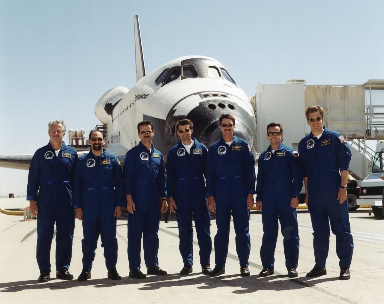 STS100-S-022 (1 May 2001) --- Six astronauts and a cosmonaut pose with their "home away from home" after the Shuttle Endeavour touched down on a desert runway at Edwards Air Force Base in California to complete the STS-100 mission. From the left are astronauts John L. Phillips, Umberto Guidoni, Chris A. Hadfield, Jeffrey S. Ashby and Kent V. Rominger, along with cosmonaut Yuri V. Lonchakov and astronaut Scott E. Parazynski. Guidoni is with the European Space Agency (ESA); Hadfield represents the Canadian Space Agency; and Lonchakov is associated with Rosaviakosmos. Touchdown occurred at 9:11 a.m. (PDT), May 1, 2001.