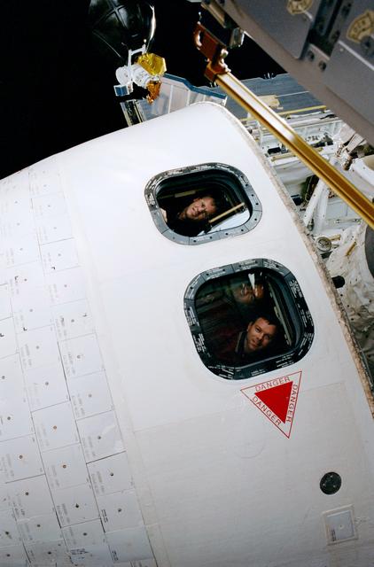 NASA image: Astronauts in the windows of the orbiter as seen during EVA