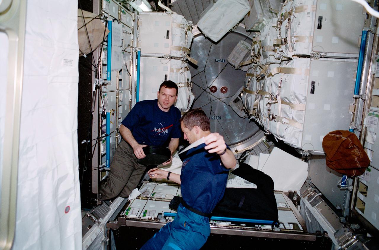 STS102-317-001 (8 - 21 March 2001) ---  Astronauts James M. Kelly (left) and James D. Wetherbee, pilot and commander, respectively, for the STS-102 mission,  participate in the movement of supplies  inside Leonardo, the Italian Space Agency-built Multipurpose Logistics Module (MPLM).