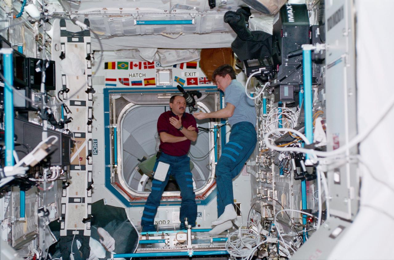 STS102-319-026 (8 - 21 March 2001) --- Cosmonauts Yury V. Usachev (left), Expedition Two commander, and Sergei K. Krikalev, Expedition One flight engineer, meet in the Destiny laboratory. Krikalev and two crew mates have just about completed their tour of duty on the International Space Station (ISS). Usachev is joined by two astronauts (out of frame) for several months' work and research on the outpost.