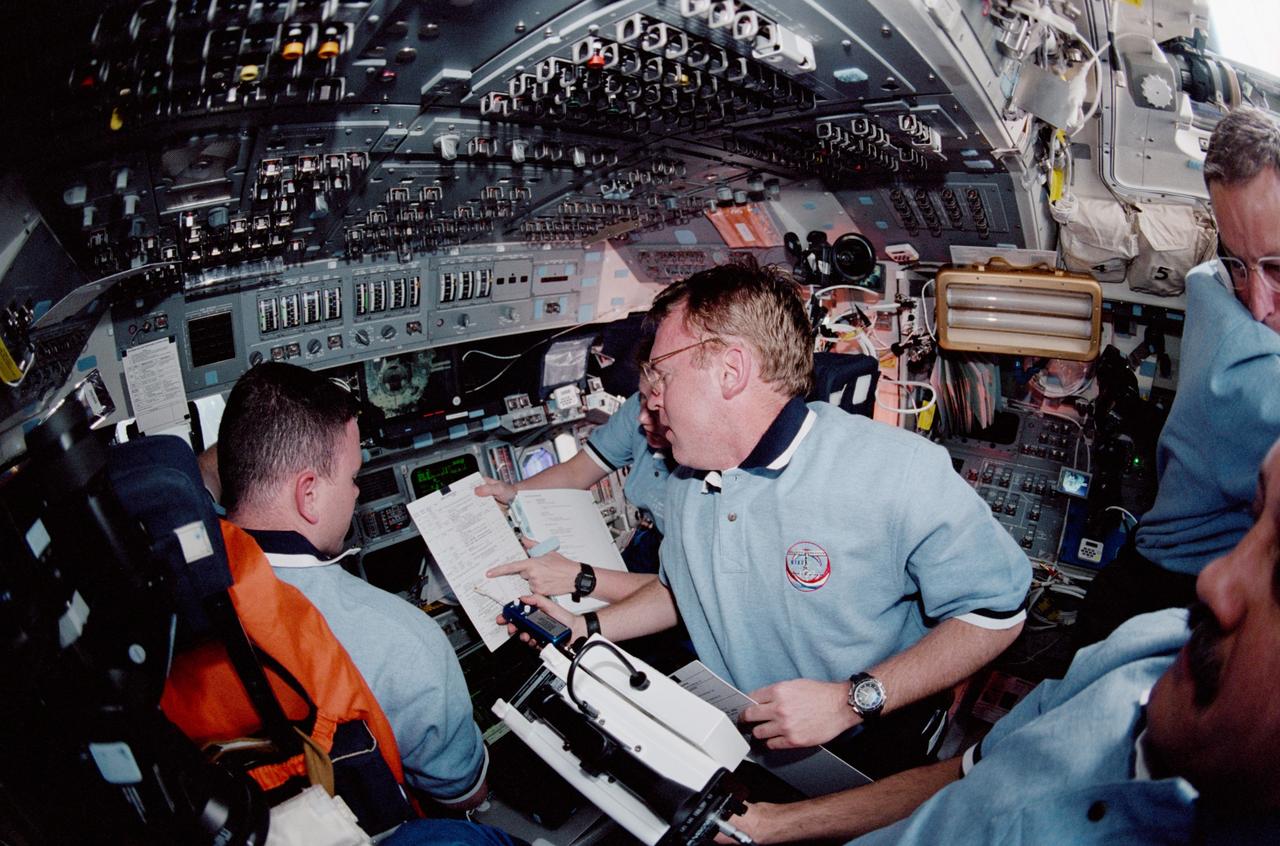 STS102-322-003 (10 March 2001) --- The STS-102 crew members huddle on the flight deck of the Space Shuttle Discovery during rendezvous operations with the International Space Station (ISS).  Astronaut Andrew S.W. Thomas, mission specialist, is at center frame. Astronaut James M. Kelly, pilot, is seated at the commander's station.  Partially visible at right edge are astronaut James D. Wetherbee, mission commander, and Yury V. Usachev, mission specialist representing Rosaviakosmos.  Usachev is assigned to assume command of the Station when a crew exchange is accomplished later in the week.