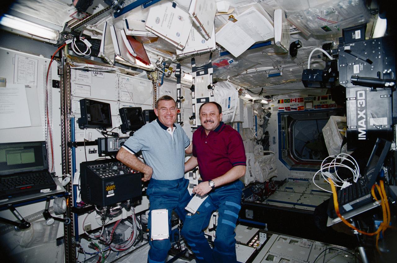 STS102-336-024 (8 - 21 March 2001) ---    Two-thirds of the Expedition Two crew  is represented in this scene in the  Destiny laboratory onboard the International Space Station (ISS).  Cosmonaut Yury V. Usachev (right) is mission commander and will be joined for several months aboard the outpost by  astronauts James S. Voss (left) and Susan J. Helms (out of frame), both flight engineers.