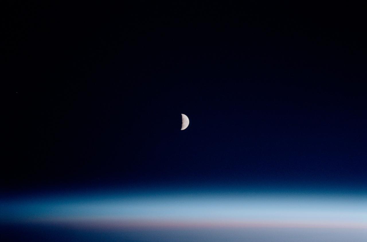 STS102-342-024 (8-21 March 2001)--- The largest percentage of astronaut out-the-window photography is scientific in nature. However, occasionally scenes such as this one showing the moon over Earth's airglow are irresistable for crew members with cameras.  The 35mm scene was recorded by one of the STS-102 astronauts from the aft flight deck of the Space Shuttle Discovery.