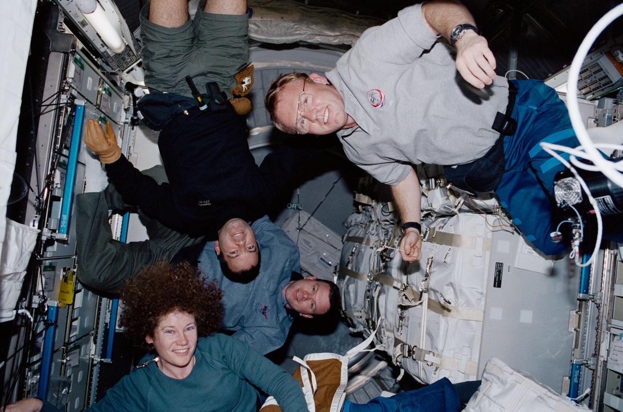 STS102-346-035 (8 - 21 March 2001) --- Four STS-102 crew members participate in the movement of supplies inside Leonardo, the Italian Space Agency-built Multipurpose Logistics Module (MPLM).    Clockwise from lower left are astronauts  Susan J. Helms, STS-102 mission specialist and Expedition Two flight engineer; James M. Kelly, STS-102 pilot; and Paul W. Richards and Andrew S.W. Thomas, both STS-102 mission specialists.