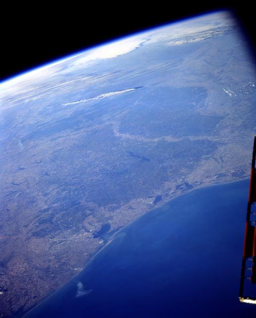 STS103-501-104 (19-27 December 1999) ---  One of the astronauts aboard the Earth-orbiting Space Shuttle Discovery used a handheld large format camera to photograph this scene which stretches from the Gulf of Mexico into Oklahoma.   Parts of Louisiana and Arkansas are also visible in the frame. The Red River snakes its way through the East Texas Piney Woods (center). The river meets with the southern edge of the Ouachita folded mountains of southern Oklahoma.  The white, linear feature north of the Red River is most likely a jet stream cloud, according to Earth scientists who studied the STS-103 collection at the Johnson Space Center (JSC).  Jet contrails can be seen flying over the clouds.  Along the Texas Gulf Coast are Galveston Bay and the greater Houston  metropolitan area.