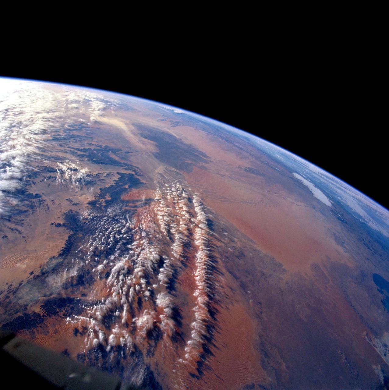 STS103-710-084 (19-27 December 1999)--- One of the astronauts aboard the Earth-orbiting Space Shuttle Discovery used a handheld 70mm camera to photograph the great sand seas which occupy northern Algeria.  They are Grand Erg Oriental (Eastern Sand Sea) and Grand Erg Occidental (Western Sand Sea). Both sand seas occupy depressions that are separated by a north-south rise called Mizab.  Ergs are areas of large accumulations of sand that take the form of actively shifting dunes, fossilized dunes, or extensive sand sheets.