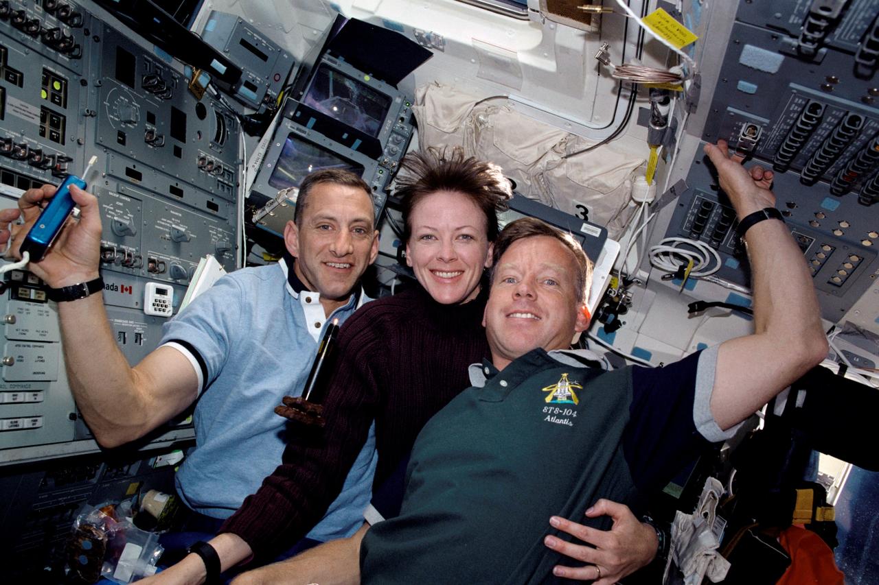 STS104-312-010 (12-24 July 2001) ---  While two crew mates moved around outside the shuttle on one of three space walks to perform work on the International Space Station (ISS), these  three astronauts supported the extravehicular activity (EVA) chores from inside the crew cabin of the Atlantis.  They are, from the left,  Charles O. Hobaugh, pilot; Janet L. Kavandi, flight engineer and mission specialist; and Steven W. Lindsey, commander.