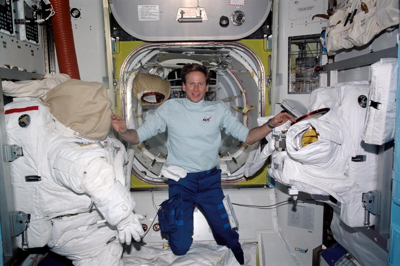 STS104-313-011 (12-24 July 2001) --- Astronaut Michael L. Gernhardt, mission specialist for STS-104, checks out the extravehicular mobility unit (EMU) space suits in the equipment lock of the newly installed Quest airlock on the International Space Station (ISS). Astronauts Gernhardt and James F. Reilly went on to utilize the new airlock to   egress the station on the occasion of the third and final space walk of the STS-104 mission.