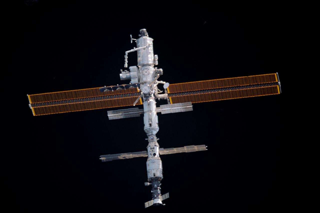 STS104-332-026 (21 July 2001) --- The International Space Station (ISS), just days after receiving the installment of the Quest airlock, was photographed by one the STS-104 astronauts during a fly-around of the orbital outpost.  The survey occurred shortly after Atlantis' undocking. The Canadarm2 or Space Station Remote Manipulator System (SSRMS) appears to be pointed toward the new airlock on the station's starboard side. The STS-104 and Expedition Two crew's joint efforts in the past several days, in which the airlock was installed and other work was accomplished, marked the completion of the second phase of the station. Within the last year (beginning in July of 2000), 77 tons of hardware have been added to the complex, including the Zvezda module, the Z1 Truss Assembly, Pressurized Mating Adapter 3, the P6 Truss and its 240-foot long solar arrays, the U.S. laboratory Destiny, the Canadarm2 and finally the Quest airlock.