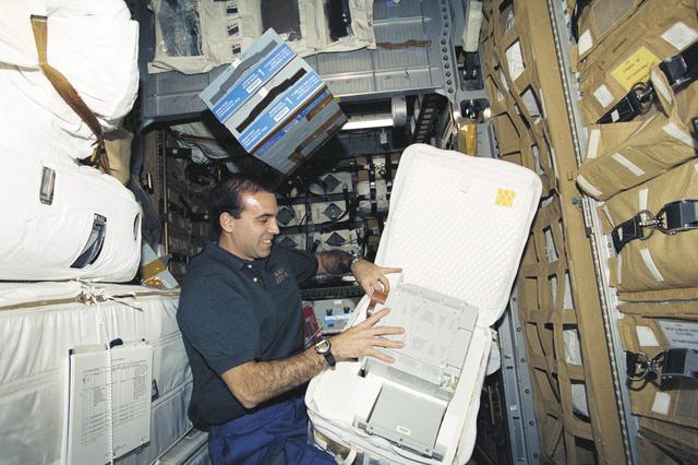 NASA image: MS Mastracchio packs a battery in a stowage bag in SpaceHab during STS-106