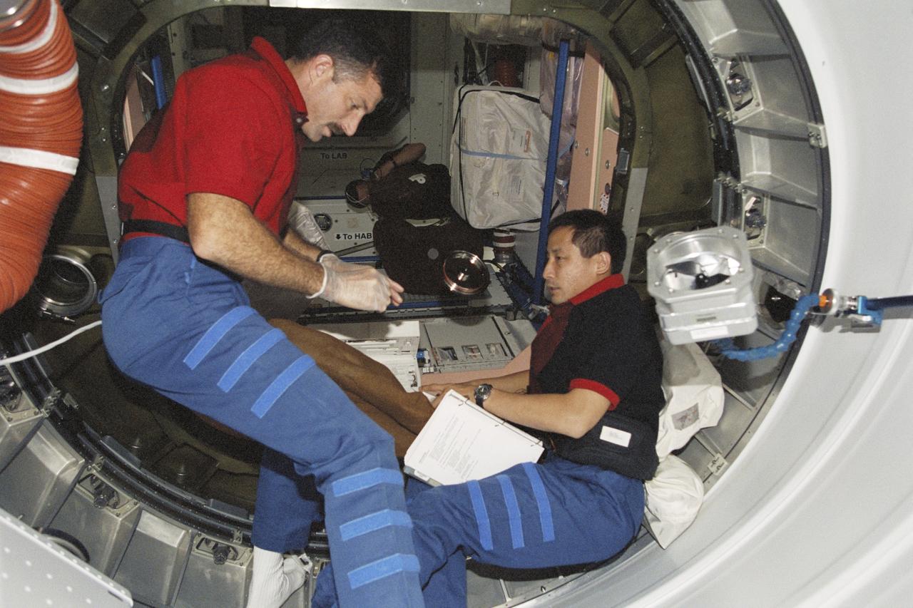 STS106-319-013 (8-20 September 2000) --- Astronauts Daniel C. Burbank (left) and Edward T. Lu, both mission specialists, work near the Pressurized Mating Adapter (PMA1) hatch between Unity node and the functional cargo block (FGB) or Zarya on the International Space Station (ISS).
